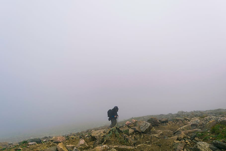 person, mountain, rocks, fog, black, hoodie, gray, pants, walking, rocky