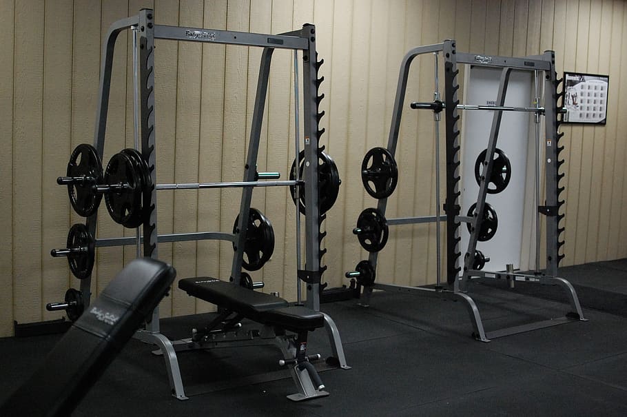 Two squat and bench racks lined up next to each other