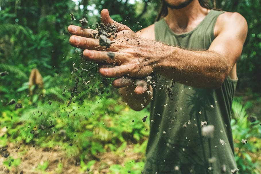 person holding dirt, soil, dirty, hand, people, man, guy, outdoor, green, grass