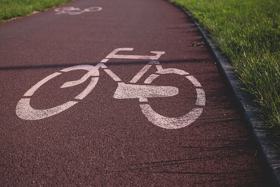 white, bicycle lane, grass field, daytime, bicycle, lane, still, signs, road, street