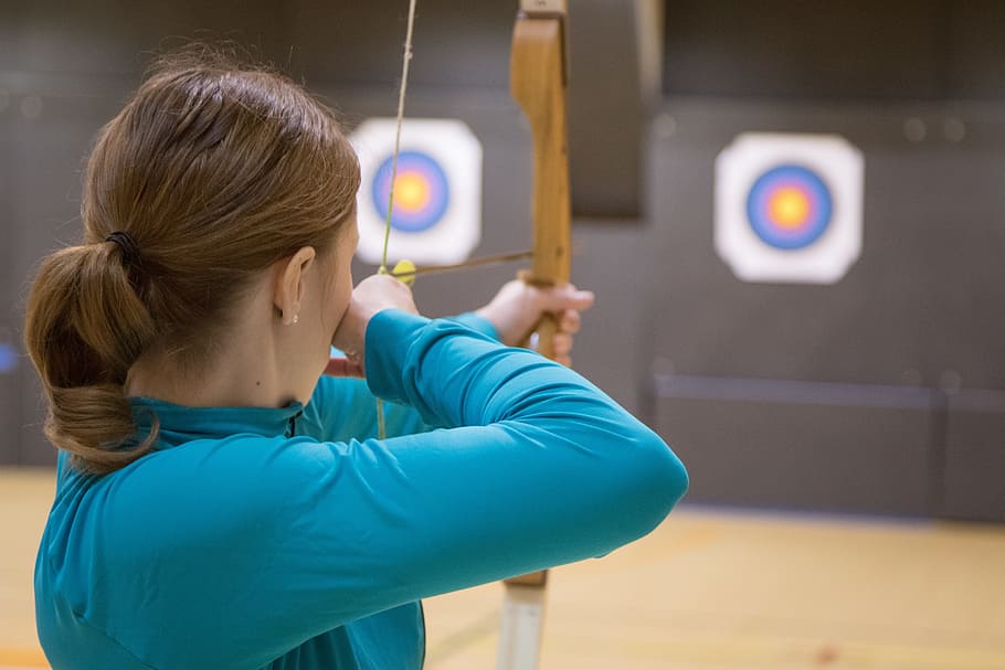 woman doing archery, archery, hobby, target, woman, one person, indoors, childhood, child, portrait