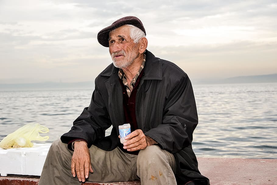 男, 身に着けている, 革のジャケット, 保持, プラスチックカップ, 座っている, コンクリート, 海, 古い, 老人