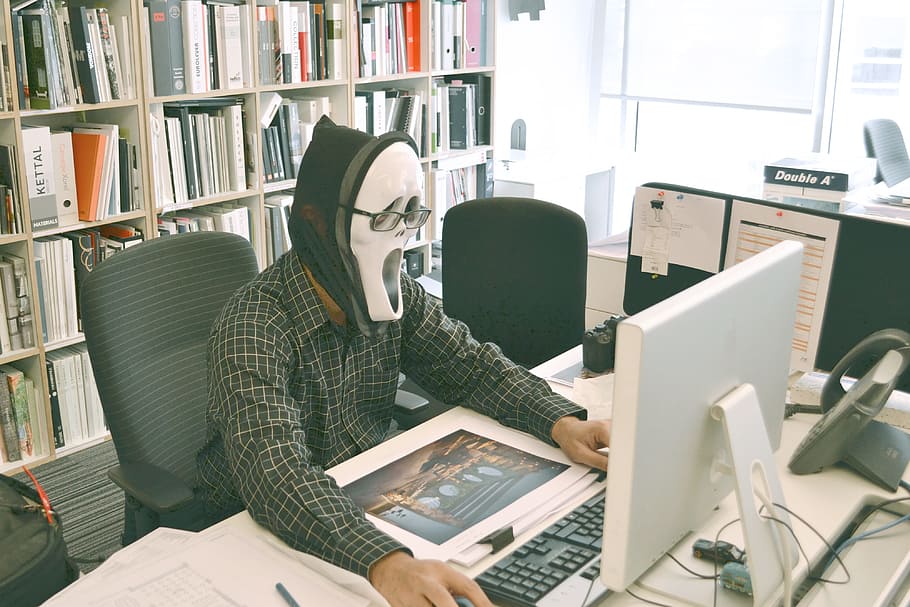 person, wearing, ghost mask, using, computer desktop, computer, keyboard, study, business, school