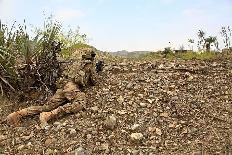 soldado, vestindo, marrom, uniforme de camuflagem, rastejando, planta, exploração, rifle, escoteiro, explorar