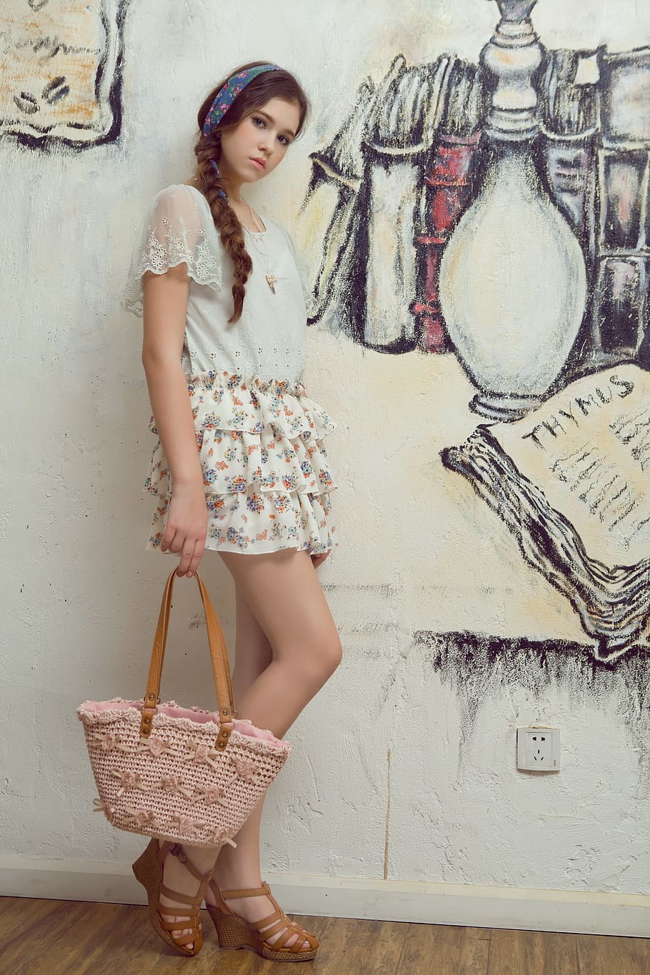 woman, holding, pink, brown, tote, bag, leaning, white, painted, wall