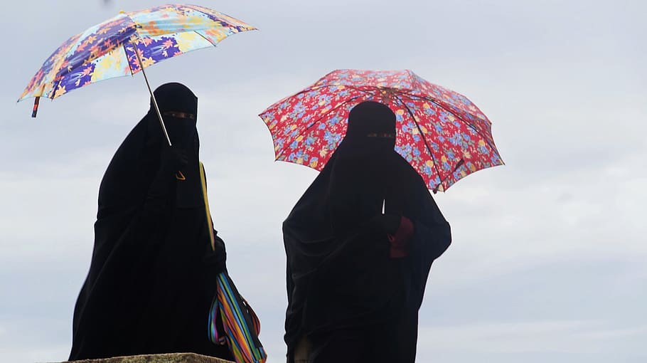 dos, persona, de pie, sosteniendo, paraguas, burka, disfraz, musulmanes, niqab, al aire libre