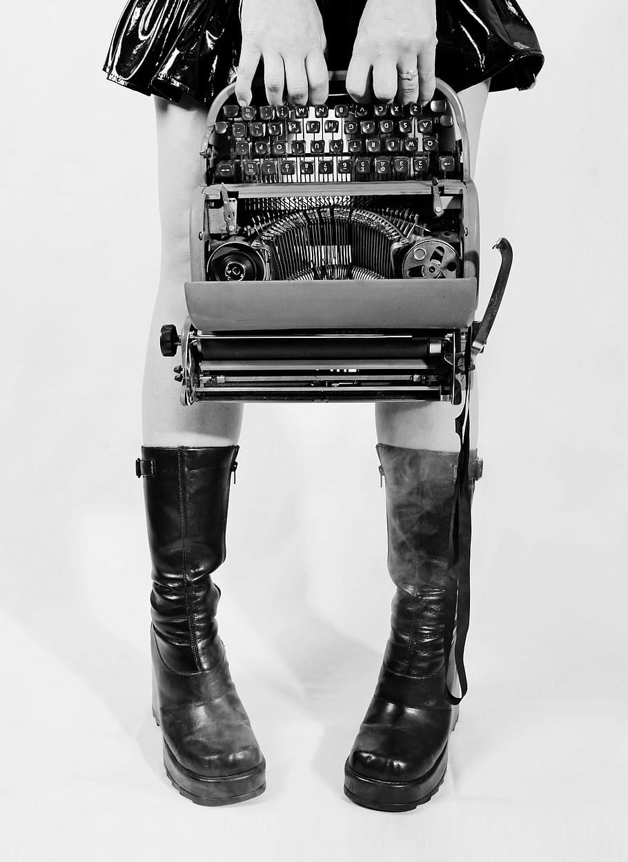 grayscale photograph, person, holding, type writer machine, conceptual, typewriter, goth, boots, legs, ribbon