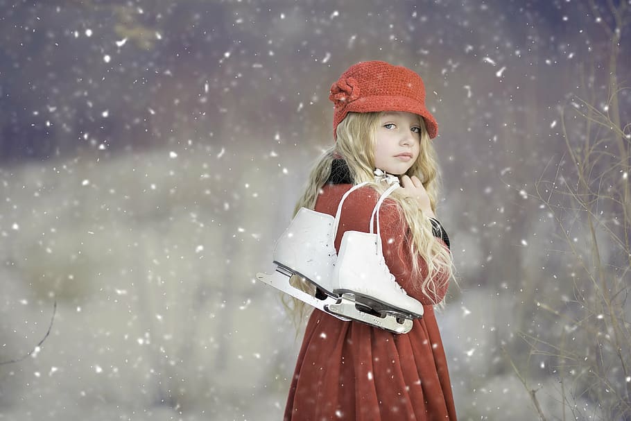 Mujer, vistiendo, rojo, abrigo, tenencia, figura, patinar, lloviendo, nieve, patines de hielo