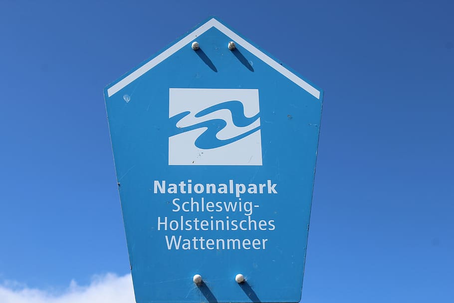 schleswig-holstein wadden sea, shield, national park, sign, blue, communication, text, western script, sky, guidance
