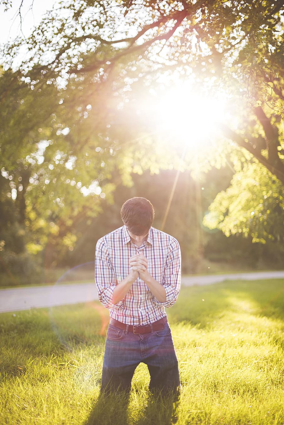 man, white, purple, plaid, dress shirt, kneeling, praying, dawn, daytime, grass