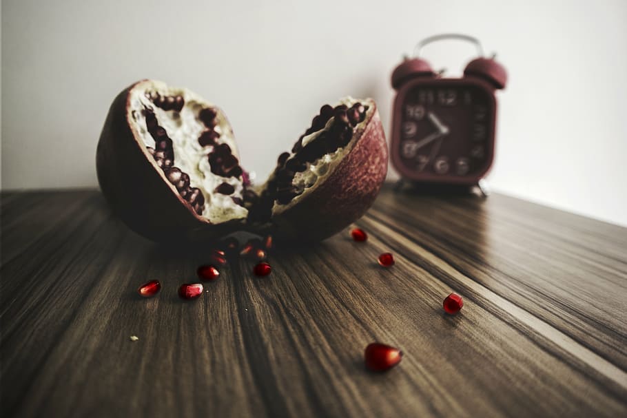 pomegranate fruit, wooden, table, bell alarm clock, pomegranate, pulp, fruit, food, vitamins, blur