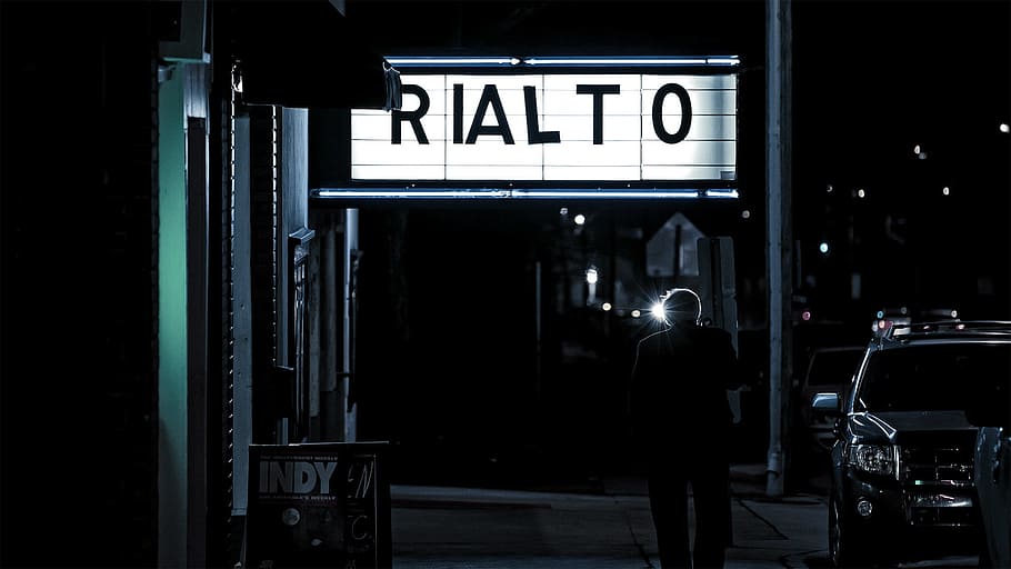 person, standing, rialto signage, Rialto, signage, movie theatre, theater, night, evening, entertainment