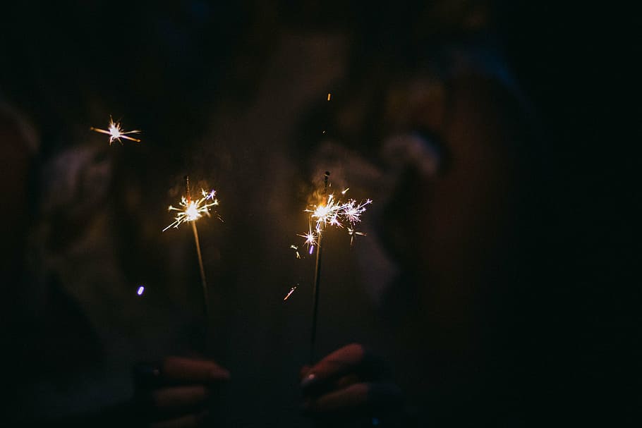person, holding, two, sparklers, firecrackers, sparkling, light, dark, night, fire