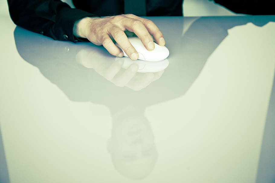 person, holding, white, cordless, computer mouse, table, computer, mouse, office, co-working