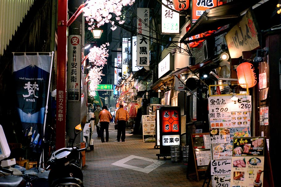 two, person, wearing, orange, shirt, walking, pathway, stores, nighttime, tokyo