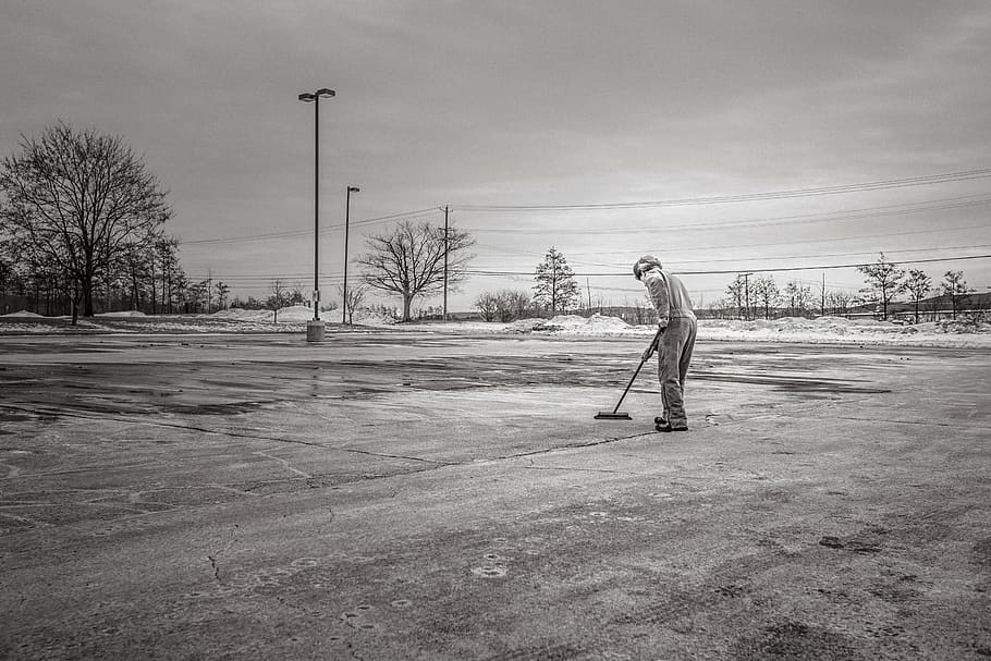 grayscale photography, man cleaning pavement, man, sweeping, floor, grayscale, broom, cleaning, concrete, lot