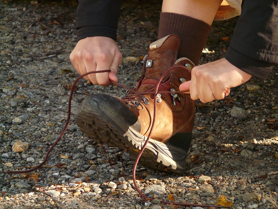 person, tying, brown, boots, daytime, tie shoes, shoe lace, shoe, sole, shoelace