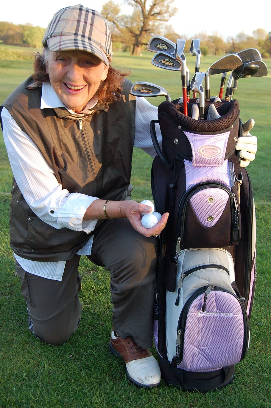 woman, holding, black, purple, golf bag, white, golf balls, older lady, retired, sport