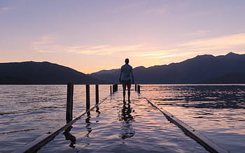 person-standing-dock-water-lake-mountain