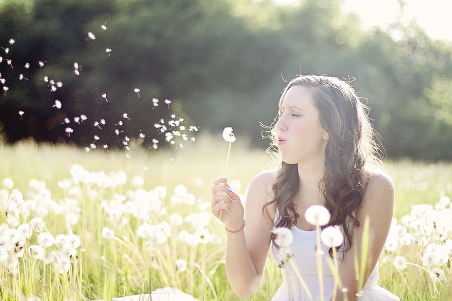 woman, wearing, white, top, dandelion grass field, daytime, dandelions, blowing, wind, summer