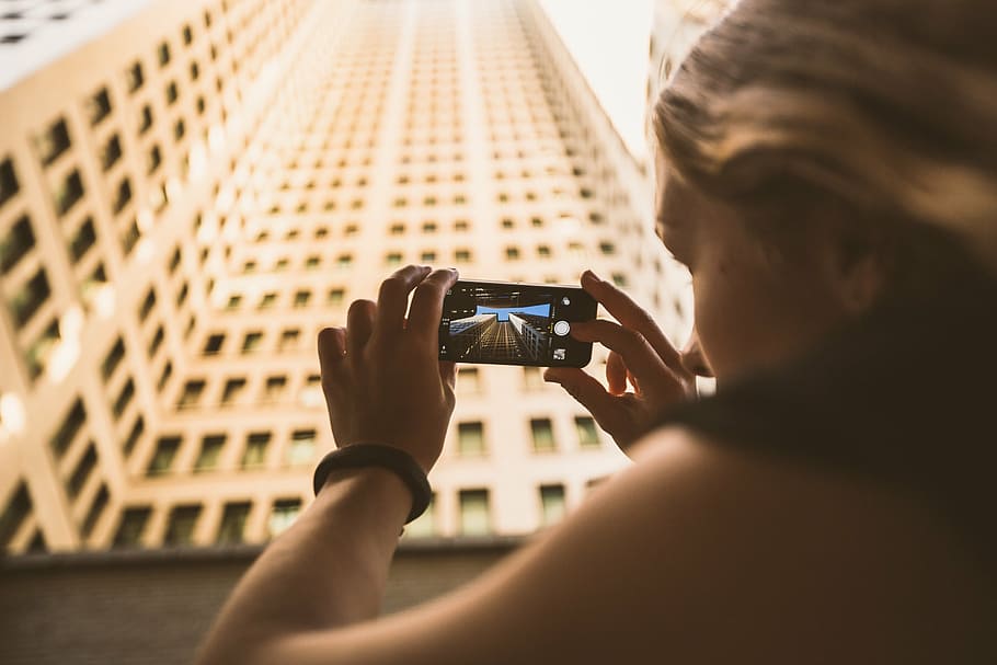 woman, holding, smartphone, taking, high-rise, building, photography, motive, display, person