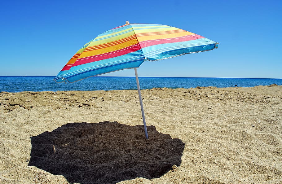 azul, rojo, amarillo, rayado, sombrilla de playa, durante el día, playa, sombrilla, arena, vacaciones