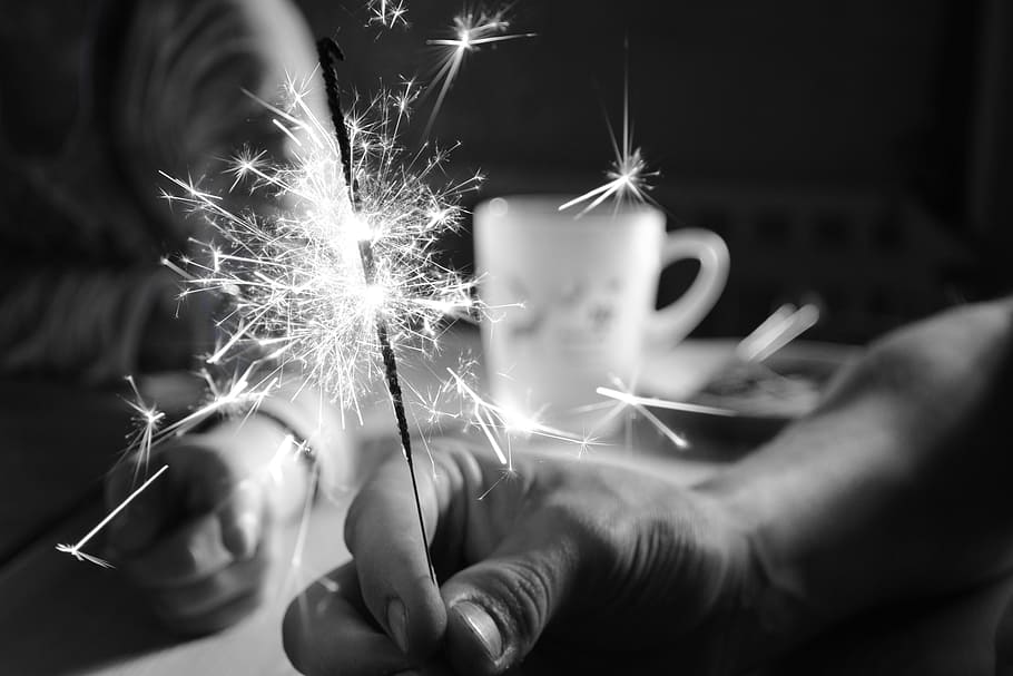 person, holding, firecrackers, mug, sparkler, celebration, black and white, new year's eve, motion, burning