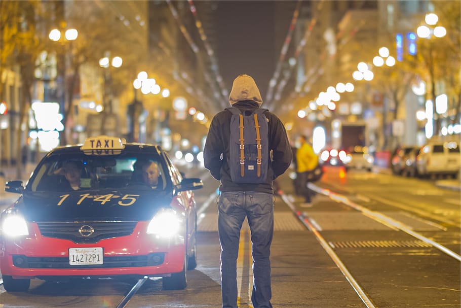 man, wearing, hoodie, backpack, standing, middle, road, taxi, cars, people