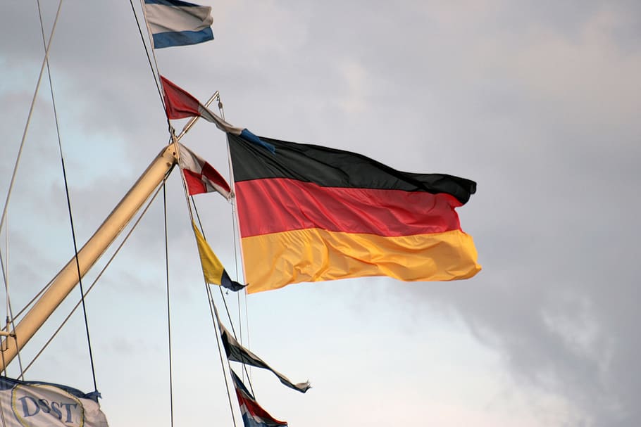 sky, flag, german, gloomy sky, wind, cloud - sky, patriotism, pole, environment, low angle view