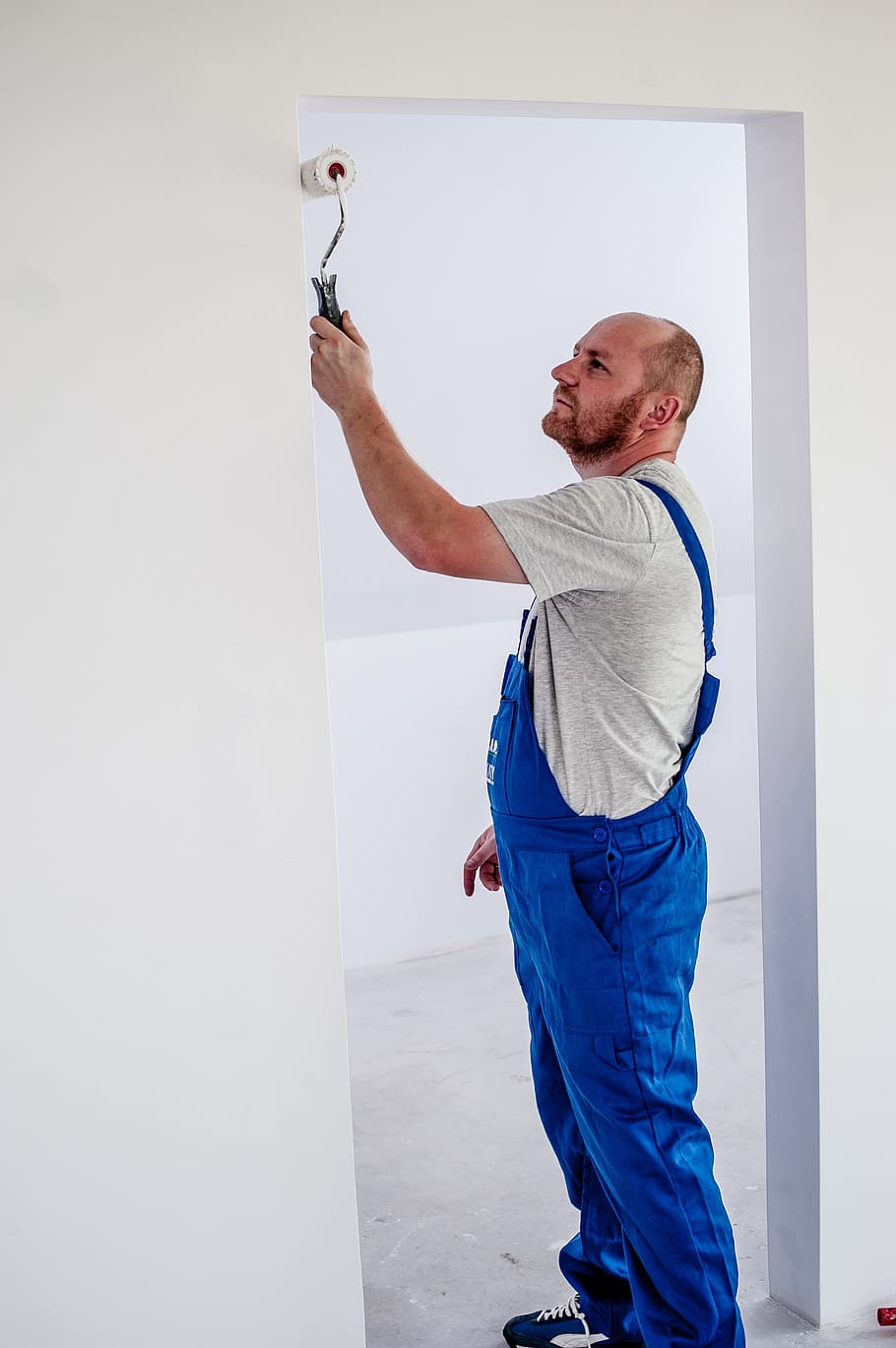 Hombre, de pie, pintura, puerta, usando, blanco, rodillo de pintura, pintor, empleado, edificio