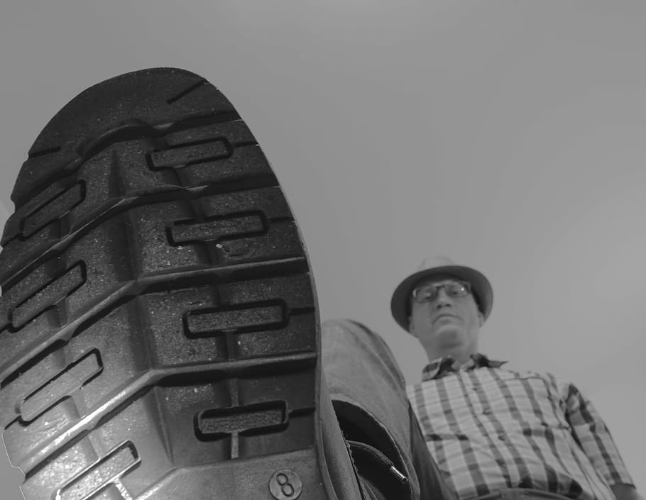 grayscale photography, man, step, camera, outdoors, trample, push, shoe, shoe sole, condescendingly
