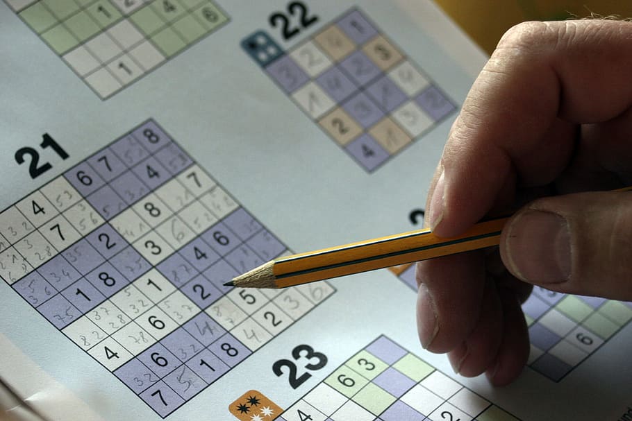 persona resolviendo sudoku, sudoku, rompecabezas, carpeta misteriosa, mano, lápiz, resolver, tarifas, ocio, pagar