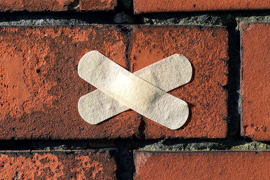 two, x, shaped, white, band aids, brown, surface, patch, stone, facade