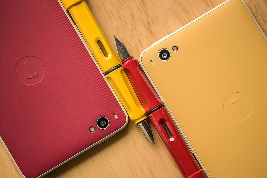 dois, smartphones, ao lado, canetas, vermelho, amarelo, tecnologia, gadgets, comunicação, móvel