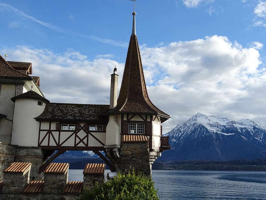 Suiza, castillo de Oberhofen, cuerpo de agua, edificio, montaña, cielo, arquitectura, estructura construida, nube - cielo, exterior del edificio