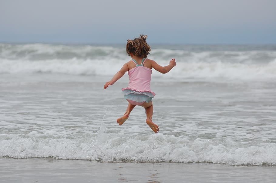 fotografia de timelapse, menina, pulando, beira mar, praia, oceano, ondas, roupa de banho, Oceano Pacífico, feliz