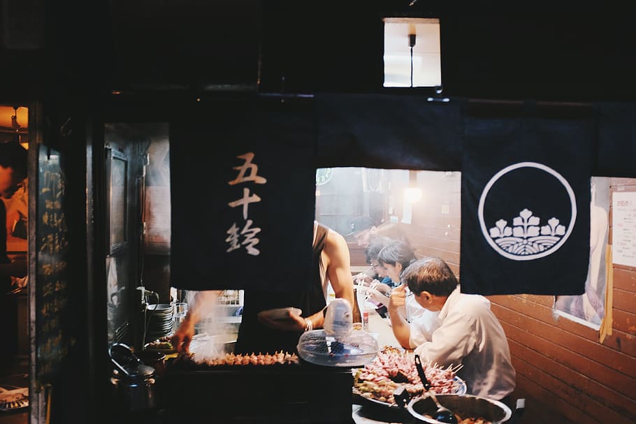 man, sits, front, counter, japanese, restaurant, people, men, women, eating