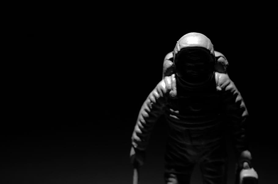 astronaut, chiaroscuro, contrast, black and white, black background, one person, studio shot, waist up, copy space, portrait