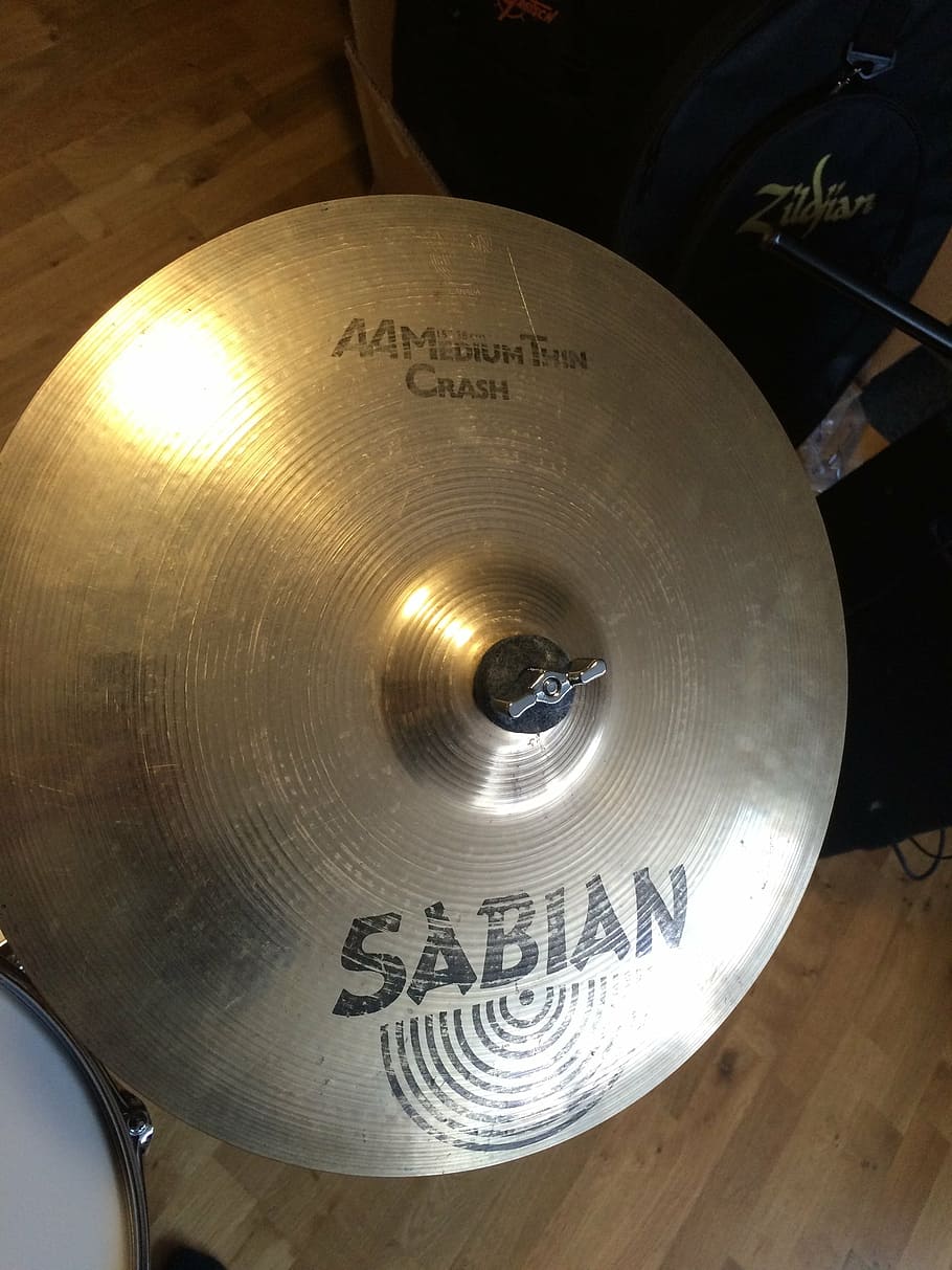 cymbal, sabian, drumset, music, instrument, text, western script, indoors, close-up, communication