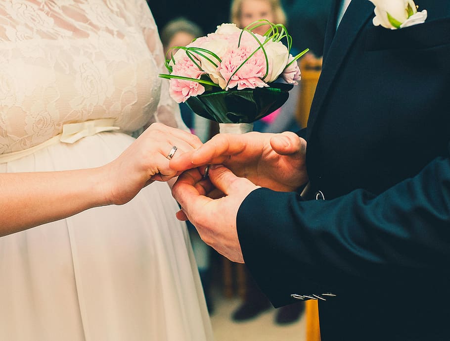 woman, wearing, white, wedding dress, man, black, suit, holding, ring, bride