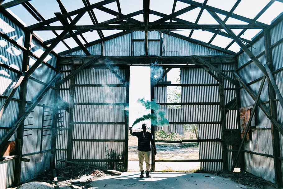 man, using, paint smoke bomb, holding, smoke, gas, building, house, shed, steel