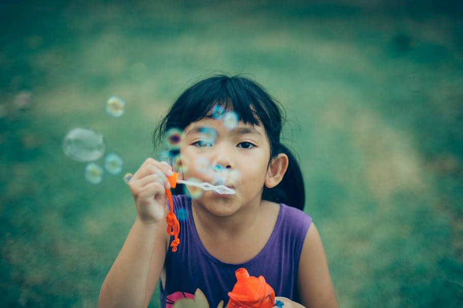girl blowing bubbles, people, kid, child, bubbles, toy, game, grass, green, childhood