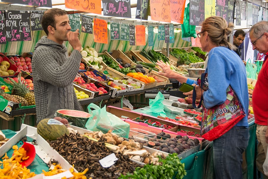 mujer, de pie, frente, tienda de verduras, mercado, puesto en el mercado, vendedor, alimentos, mercado local de agricultores, frisch