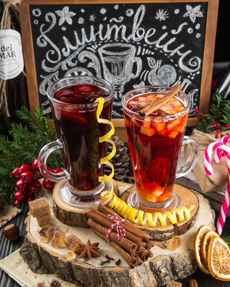 two, filled, clear, glass mugs, brown, wood slab coasters, mulled wine, drink, wine, warmly