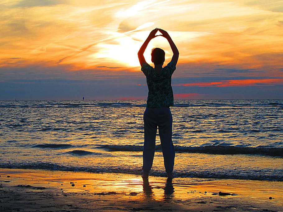 person, standing, beach, rising, hand, boy, sun, sea, waves, sunset
