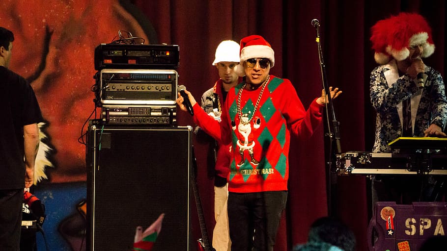 hombre, sosteniendo, instrumento de viento, al lado, amplificador de guitarra, Santa Hat, fiesta de Navidad, música en vivo, cantante, banda