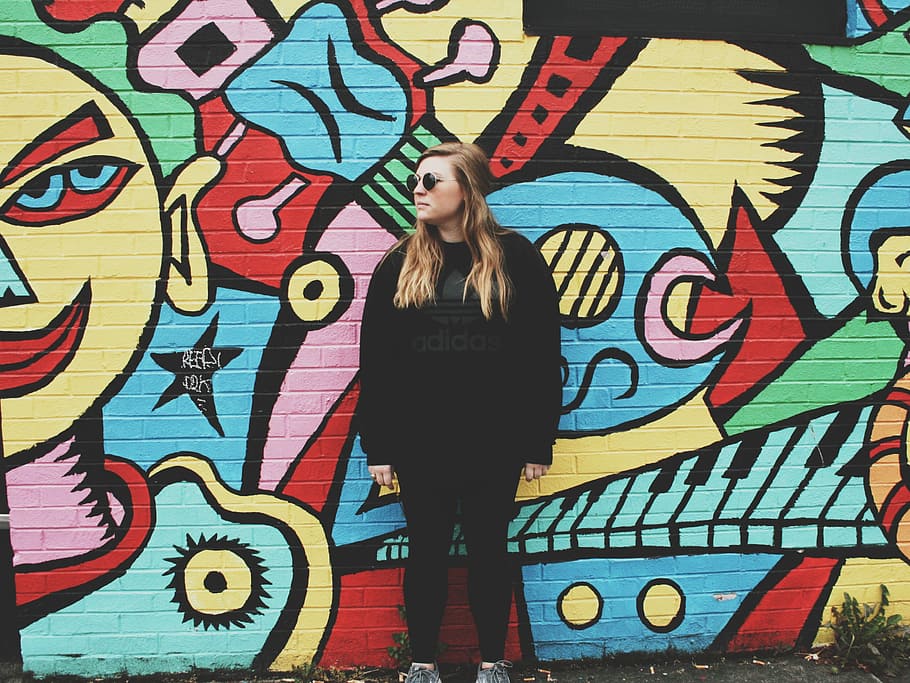 woman, wearing, black, shirt, leaning, back, graffiti wall, black shirt, back on, graffiti