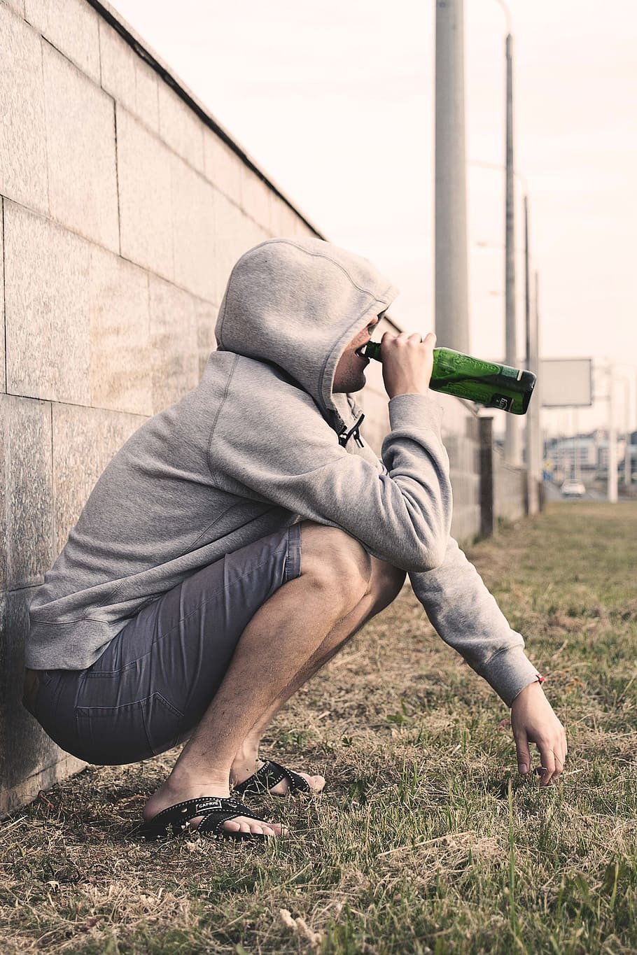 man, gray, hoodie drinking, bottled, drink, alcoholism treatment, addiction treatment, rehabilitation, alcohol, alcoholic beverage