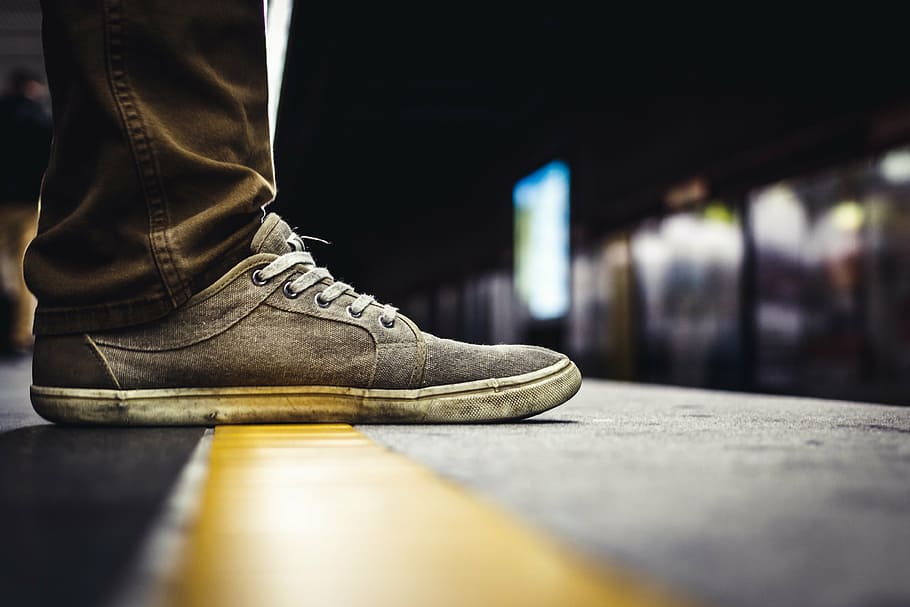 selective, focus photo, person, wearing, gray, white, suede low-top shoe, brown, jeans, yellow