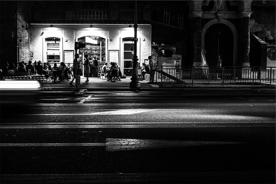 restaurant, people, night, patio, street, lamp posts, sidewalk, black and white, architecture, built structure